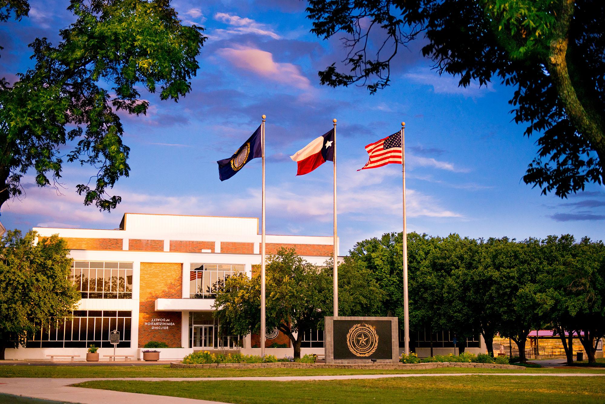 The business building with three flags in front of it.